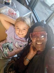 Woman in vibrant traditional dress holding pottery during a cultural event in Nigeria.