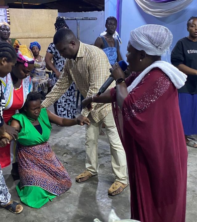 A child held by a volunteer during a community event outdoors, showcasing care.