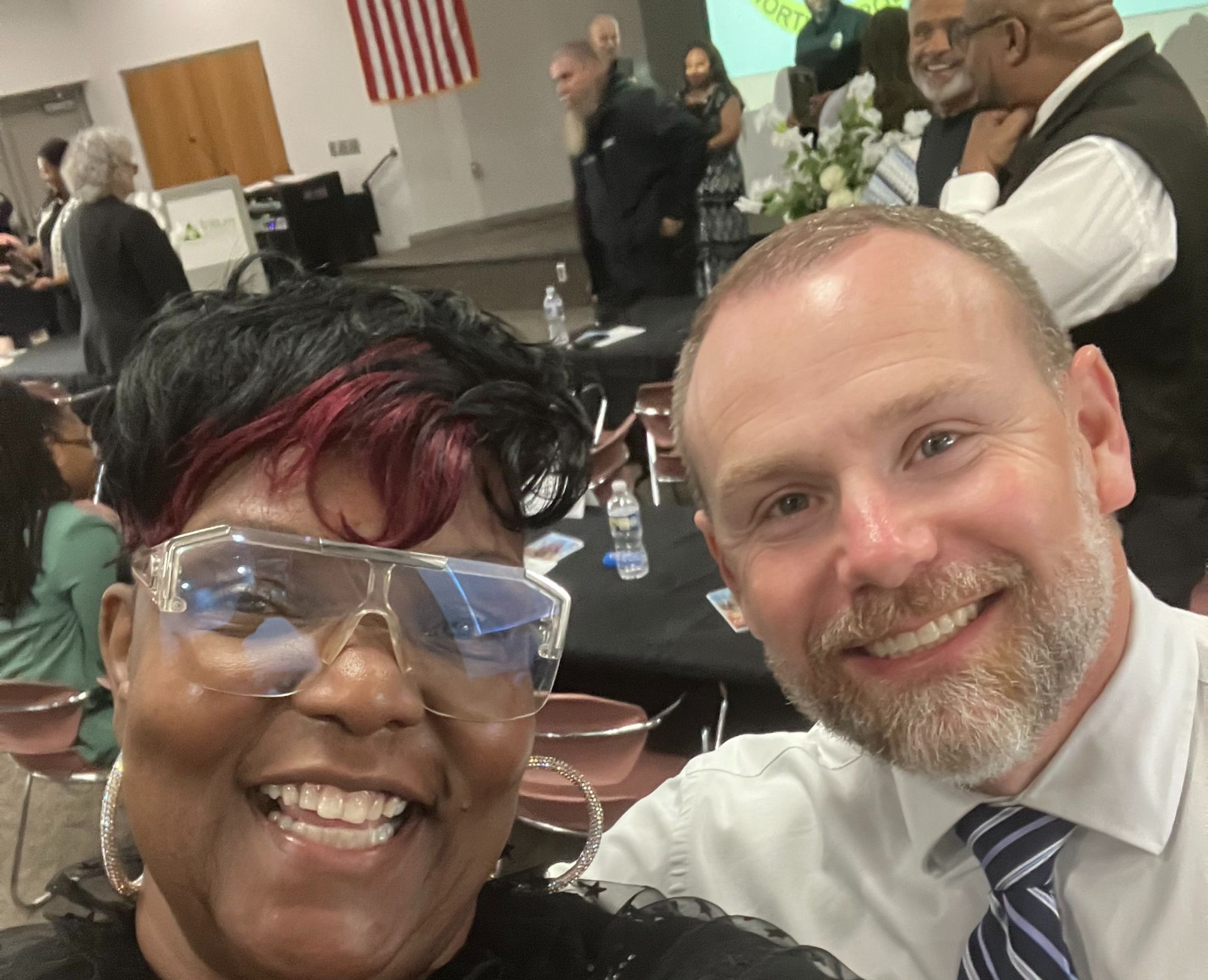 Charity worker distributes beverages to children in an African village, showcasing community support.