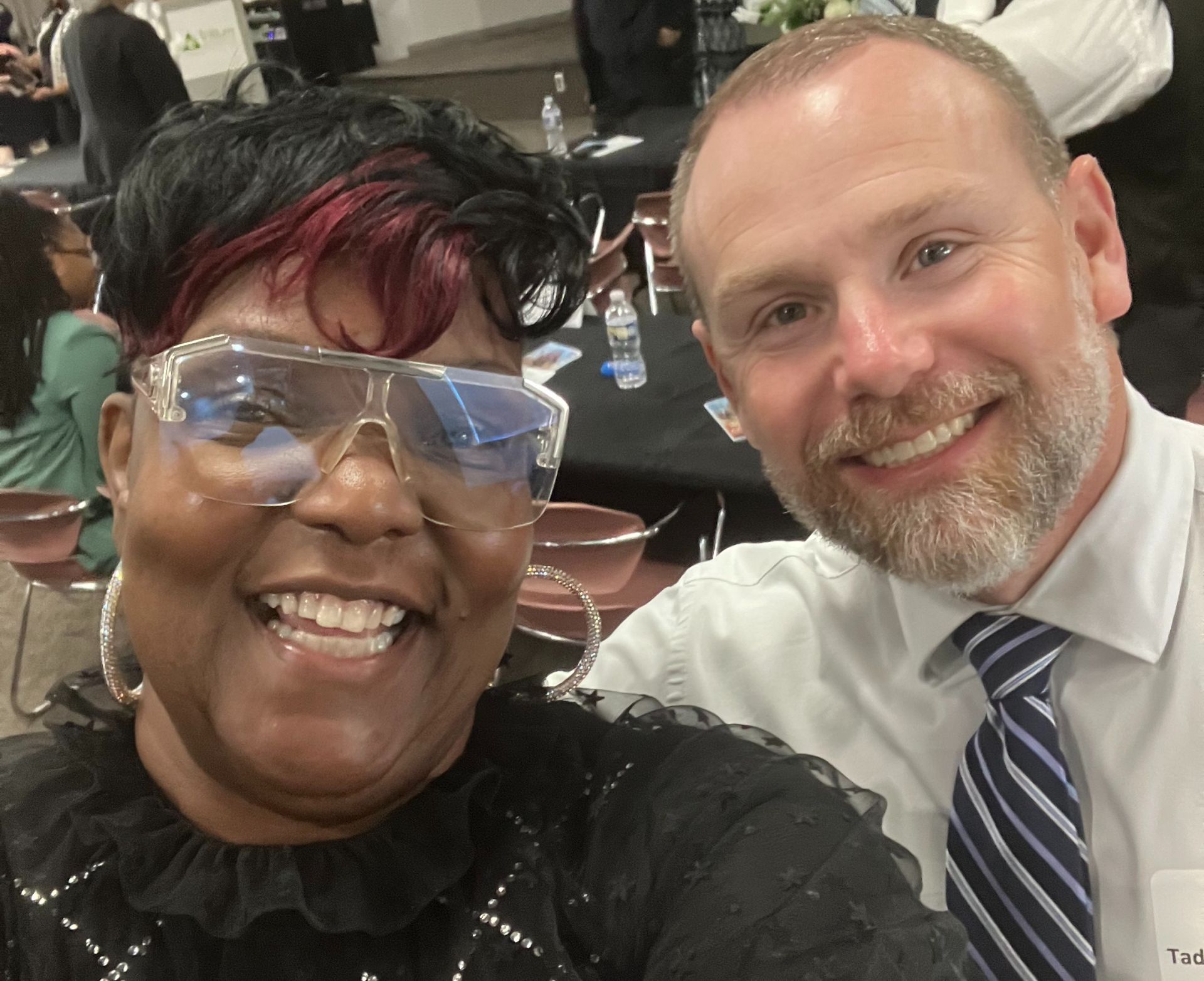 Charity worker distributes beverages to children in an African village, showcasing community support.